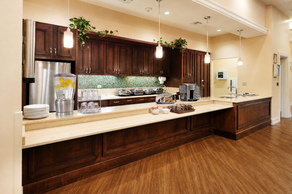 Community serviette and coffee bar at Artis Senior Living of Palm Coast with infused water, a coffee station, and fresh cookies