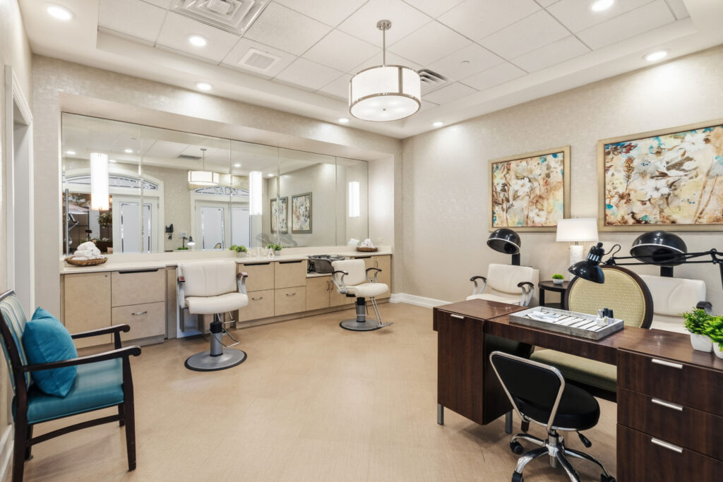 On-site salon and spa at Artis Senior Living of Palm Coast with styling chairs, a manicure station, and hair dryers