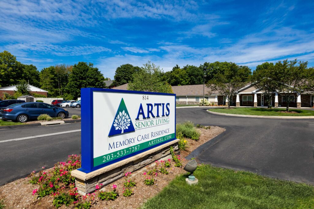 Monument sign at the entrance to Artis Senior Living of Branford, address 814, reading 'Artis Senior Living Memory Care Residence,' phone 203-533-7287, artissl.com
